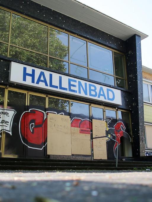 Die Eingangstüren eines geschlossenen Hallenbades in Duisburg ist mit Spanplatten verschlossen