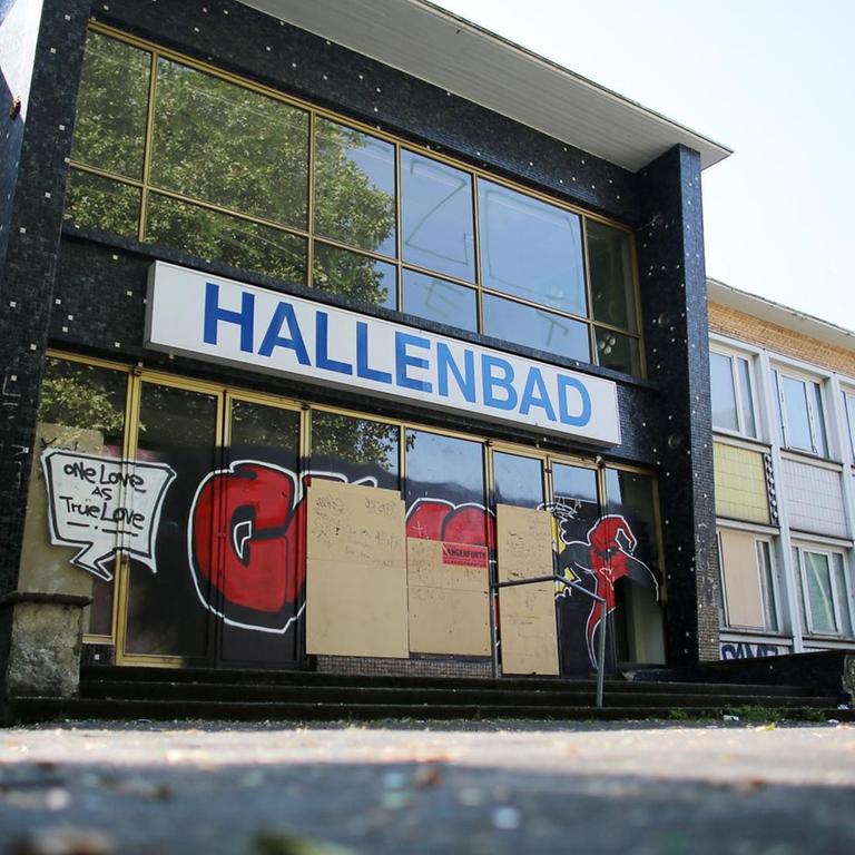 Die Eingangstüren eines geschlossenen Hallenbades in Duisburg ist mit Spanplatten verschlossen
