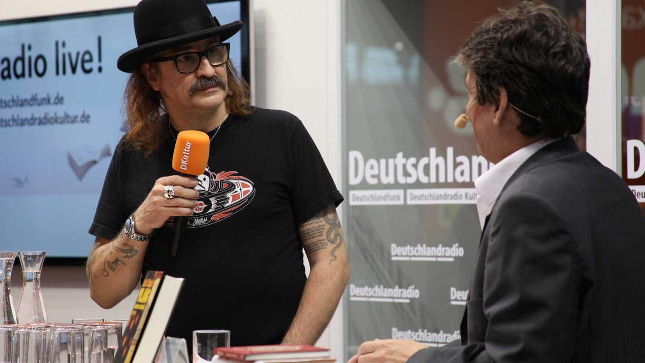 Der Musiker Axel Hacke mit Moderator Joachim Scholl auf unserer Deutschlandradiobühne bei der Frankfurter Buchmesse 2015.