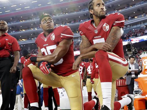 Drei Spieler der NFL-Mannschaft "San Francisco 49ers" knien während der Nationalhymne vor einem Football-Spiel