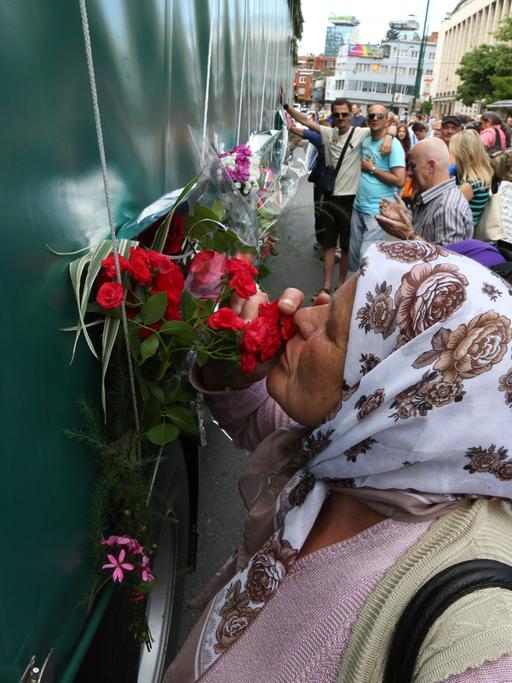 Eine alte Frau küsst Blumen an einem Konvoi in Sarajevo, mit dem die 175 neu identifizierten Leichen des Srebrenica-Massakers von 1995 transportiert werden.
