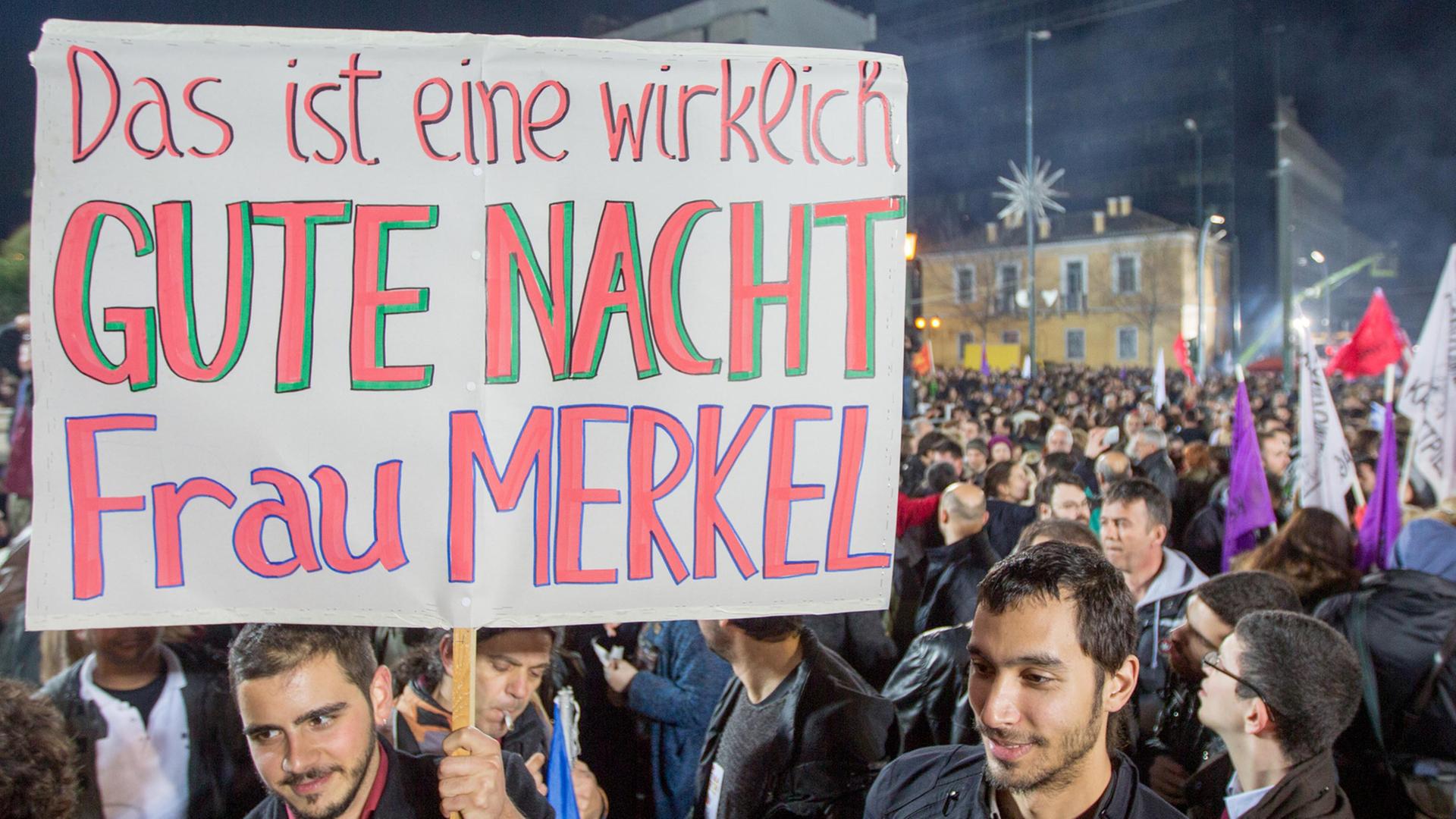 Syriza-Anhänger halten ein Schild hoch mit der Aufschrift "Das ist eine wirklich GUTE NACHT Frau Merkel".