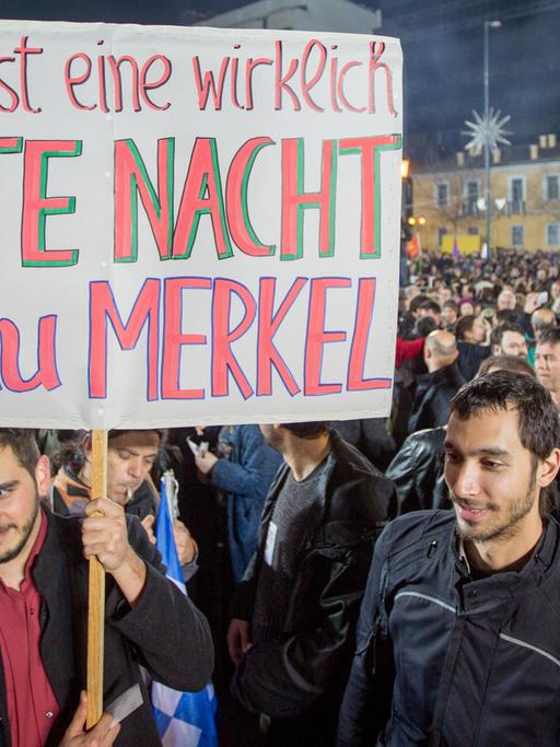 Syriza-Anhänger halten ein Schild hoch mit der Aufschrift "Das ist eine wirklich GUTE NACHT Frau Merkel".