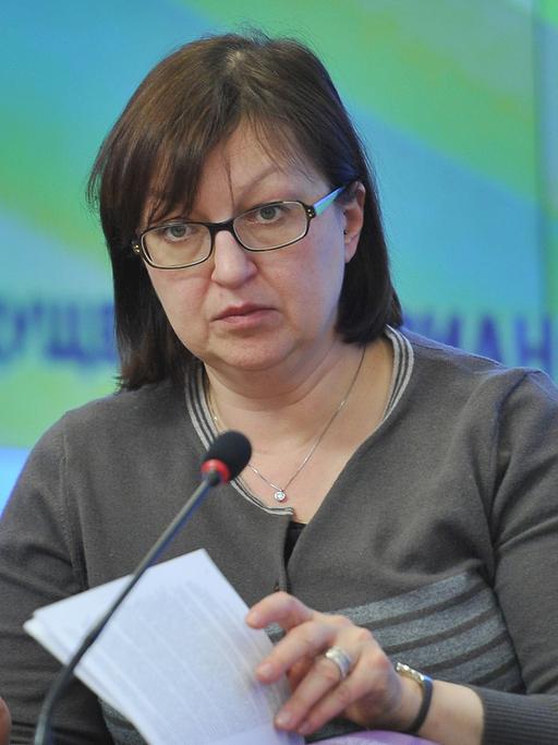 Galina Timtschenko an einem Tisch mit Mikrofon