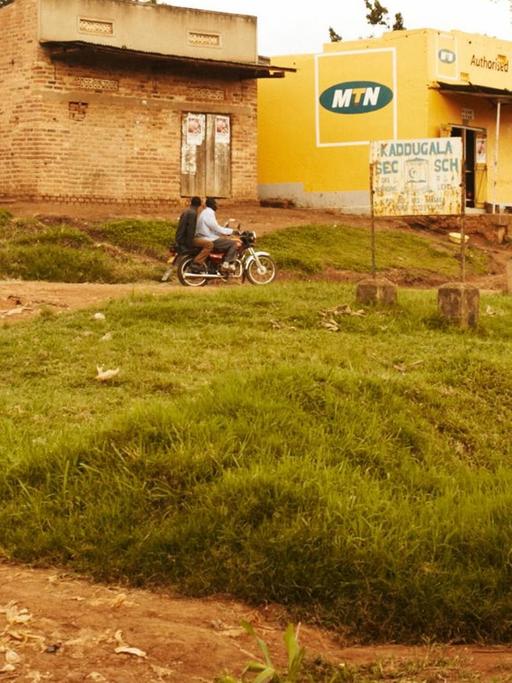 Eine Frau steht in Kampala/Uganda am Straßenrand