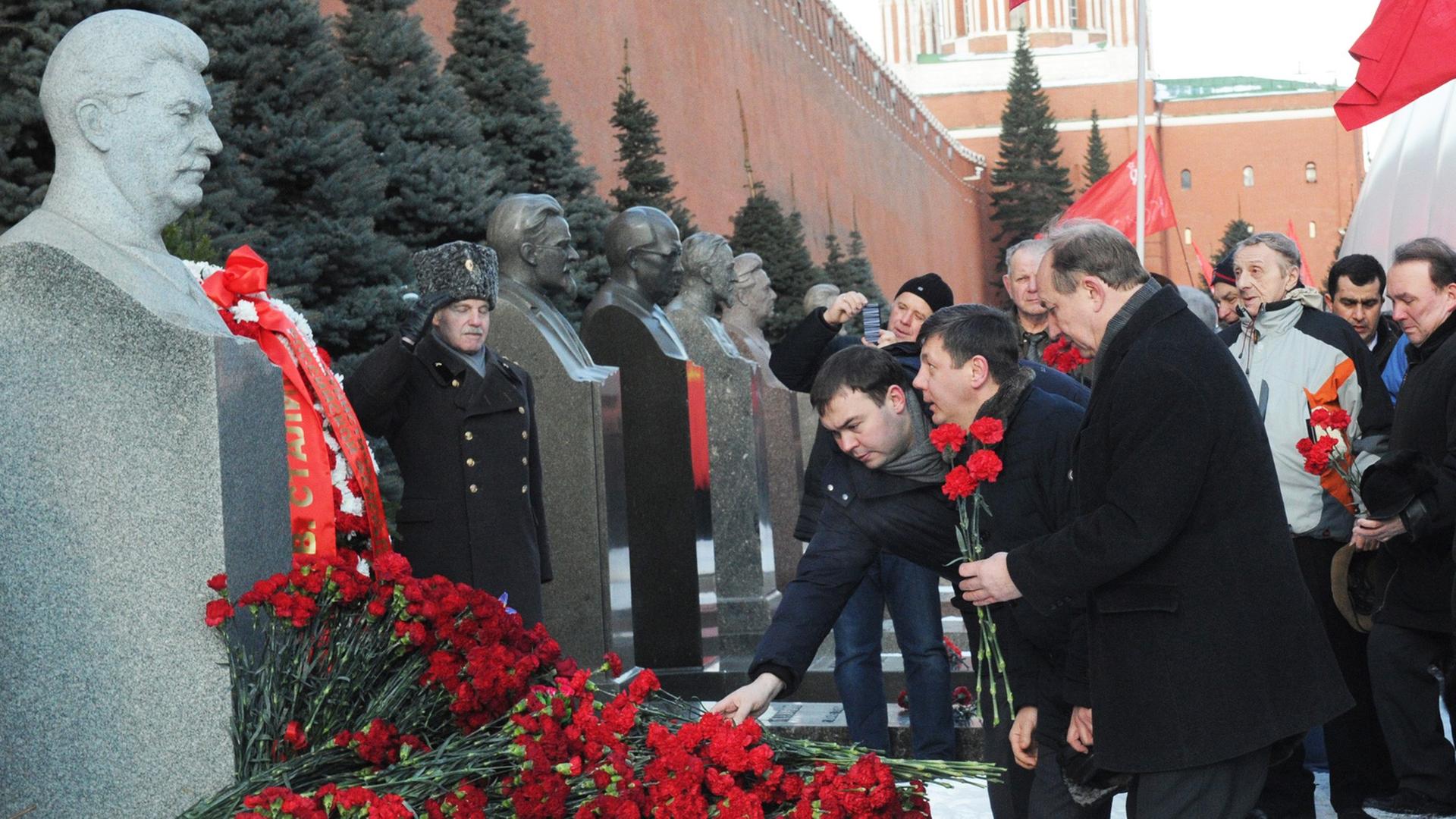 Russische Politiker legen an einer Stalin-Büste in Moskau im Mai 2013 Blumen nieder.