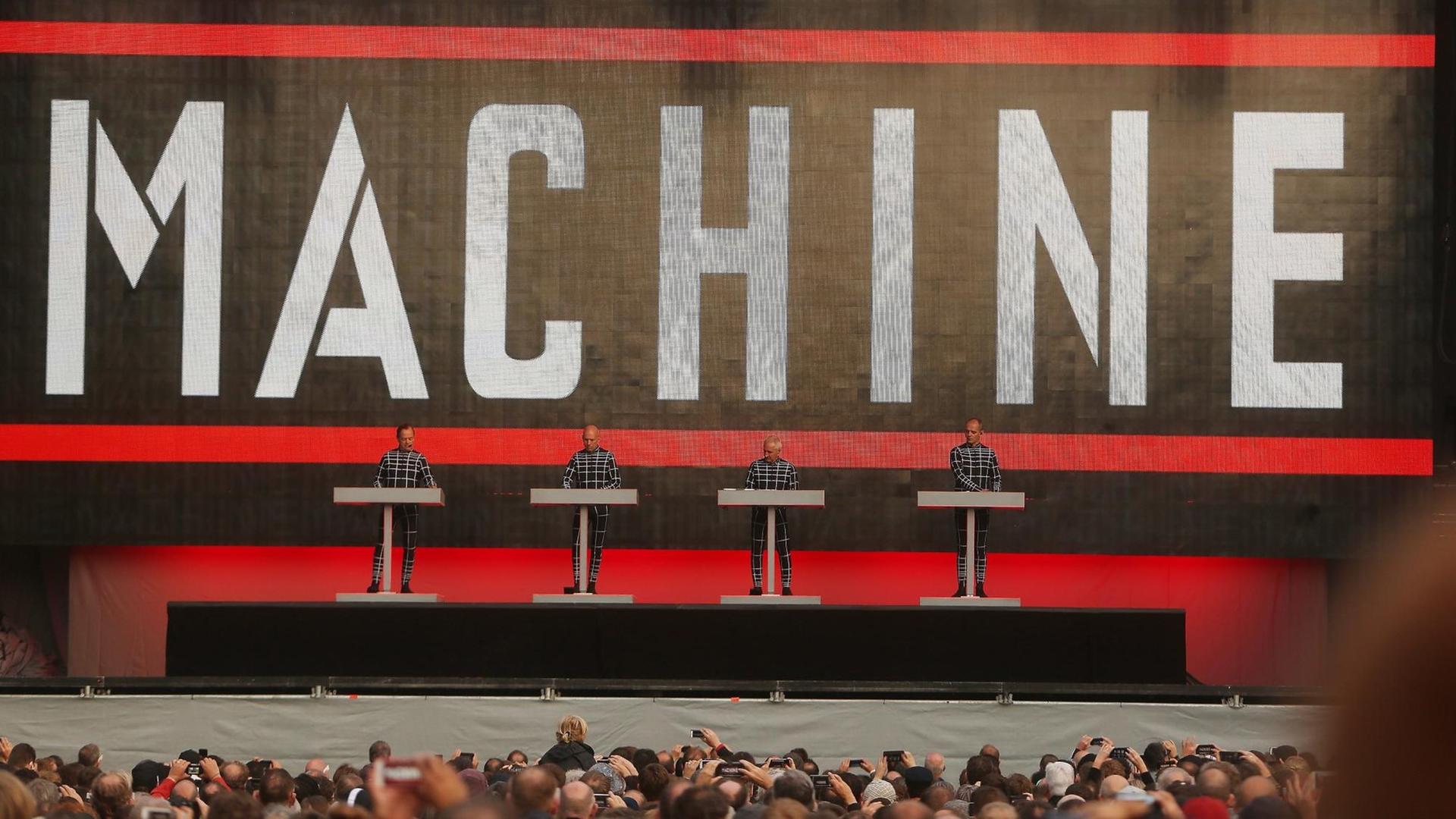 Die Elektro-Pop Band «Kraftwerk» tritt in Düsseldorf auf. Die vier Musiker stehen vor einem riesigen Schriftzug "Machine".