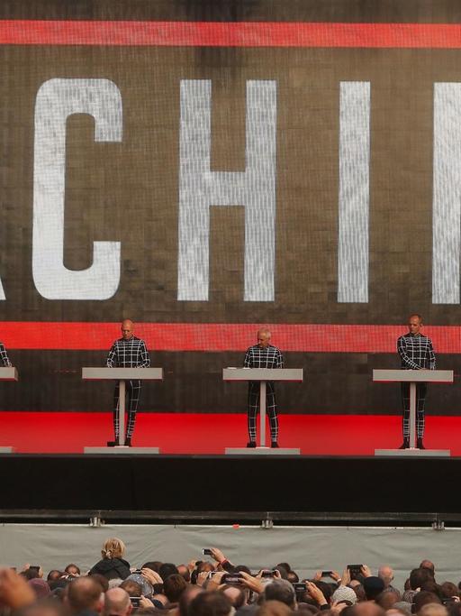 Die Elektro-Pop Band «Kraftwerk» tritt in Düsseldorf auf. Die vier Musiker stehen vor einem riesigen Schriftzug "Machine".
