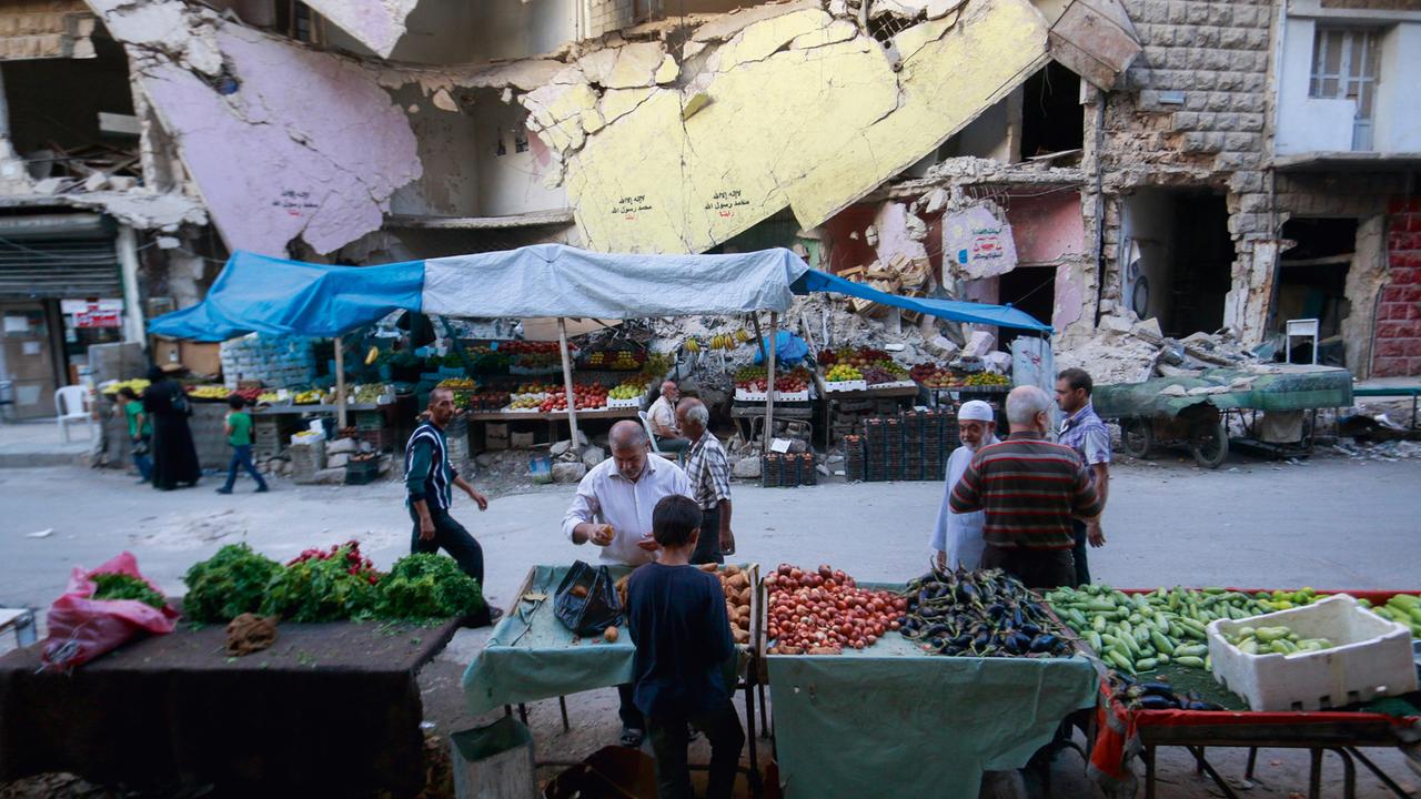 Menschen kaufen Obst und Gemüse auf einem Markt in Aleppo.