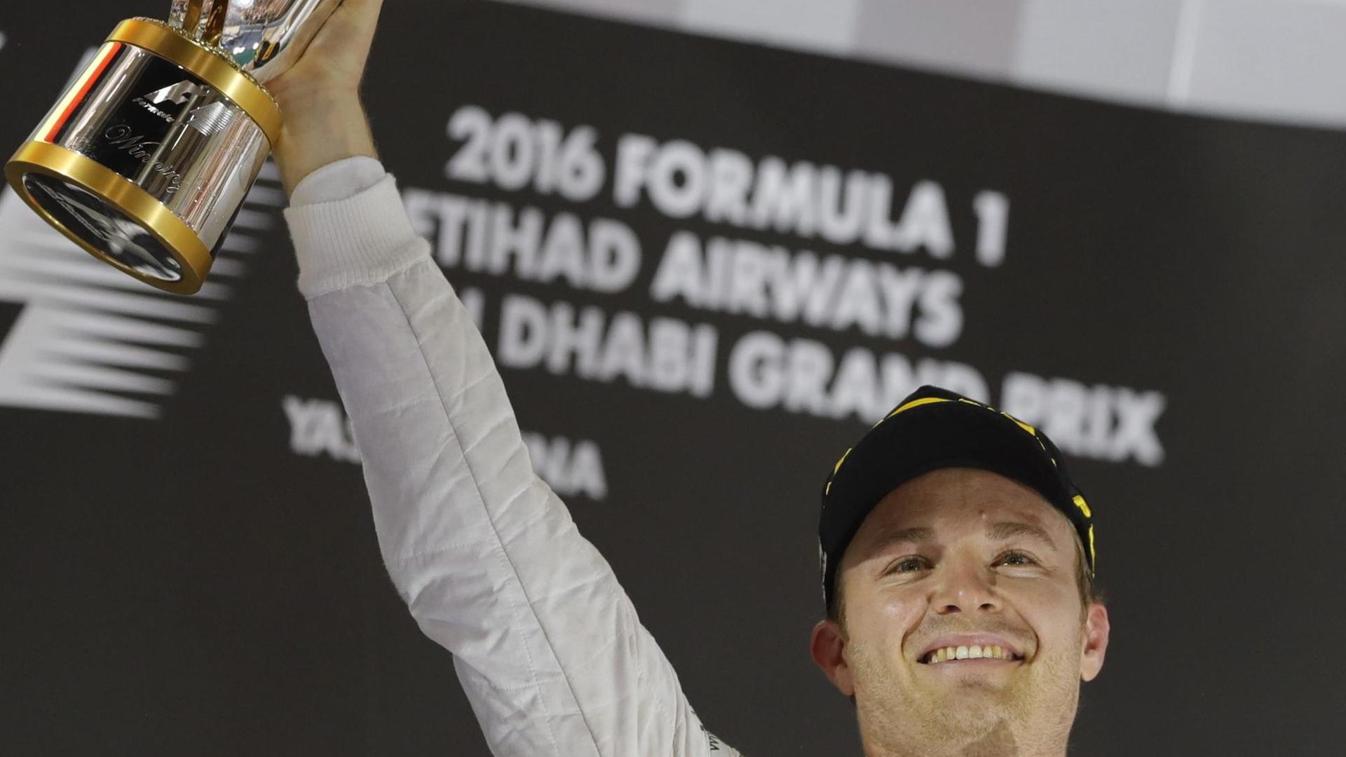Nico Rosberg jubelt über seinen Weltmeister-Titel in der Formel 1 und hält den Pokal hoch.
