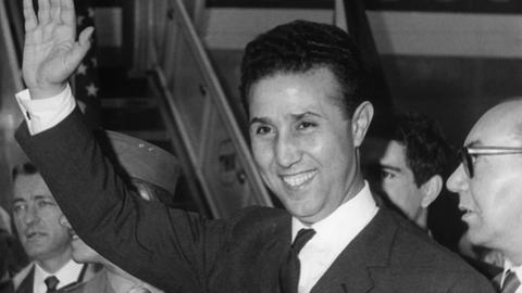 Der damalige algerische Staatspräsident Ahmed Ben Bella, winkend, schwarz-weiß-Aufnahme.