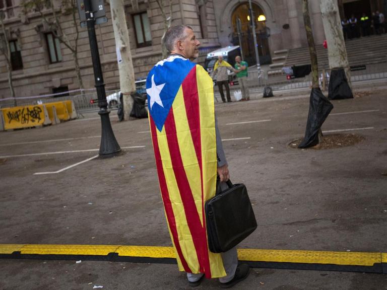 Ein Mann, bekleidet mit einer "Estelada", einer Unabhängigkeits-Fahne, vor dem katalanischen Justizgebäude in Barcelona/Spanien am 22.09.2017.