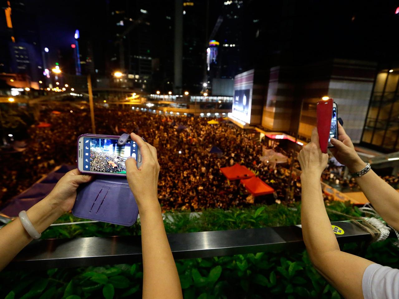 Smartphone-Besitzer machen Fotos von den Protesten vor den Regierungsgebäuden in Hongkong.