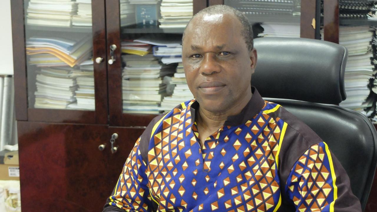 Der Direktor des Nationalmuseums von Tansania sitzt an seinem Schreibtisch.