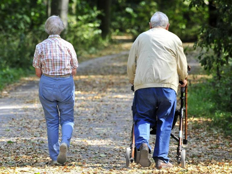 Hannover, 03.09.16: Zwei Senioren laufen durch den Park, einer mit Rollator.