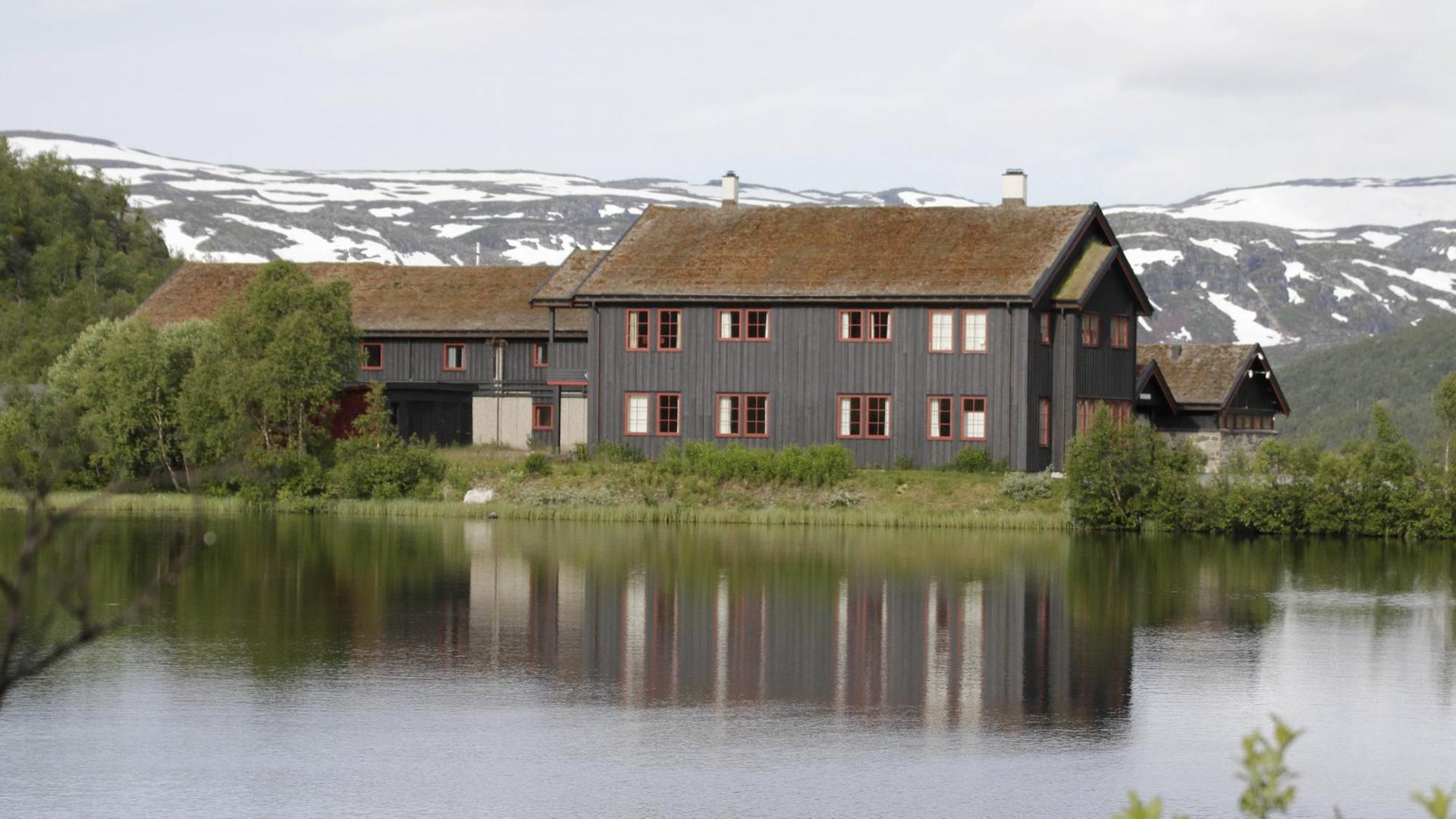 Haus an einem See in grüner Landschaft