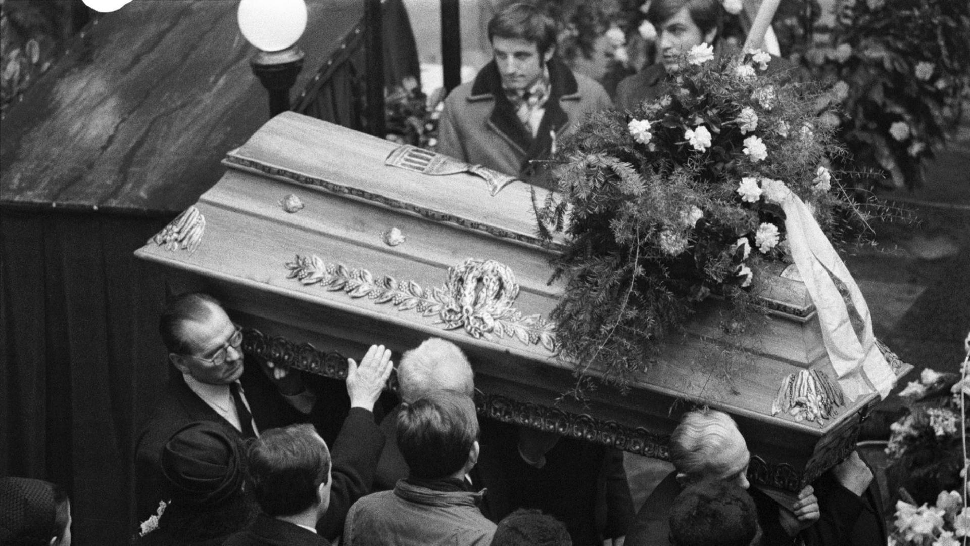 Zeitgenössisches Foto der Beerdigung des Studenten Jan Palach in Prag - ein Sarg wird im Innenhof des Karolinums, der Karlsuniversität, durch eine Menge getragen.