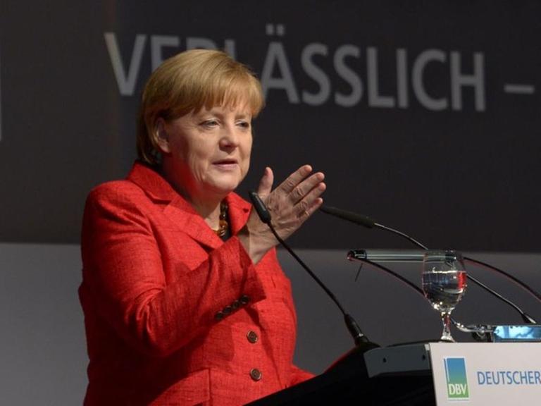 Angela Merkel auf dem Bauerntag 2013 am Rednerpult. Hinter ihr das Logo des Verbandes.