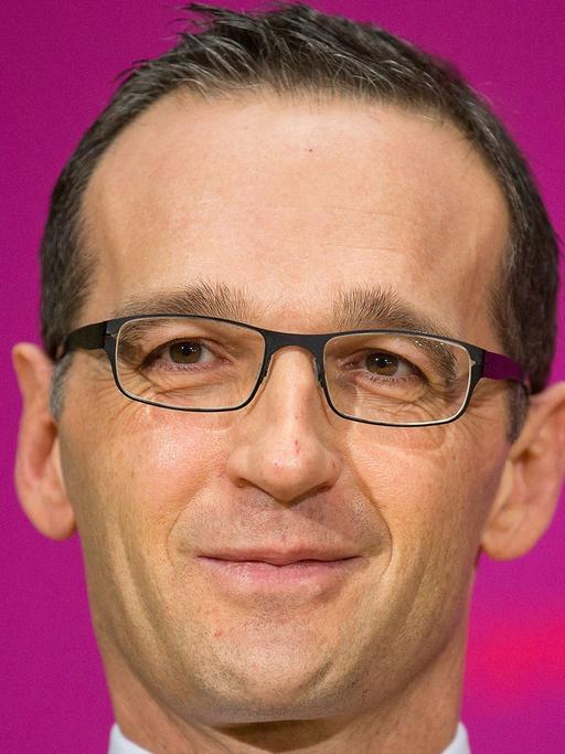 Vor pinkfarbenem Hintergrund schaut Justizminister Heiko Maas in die Kamera