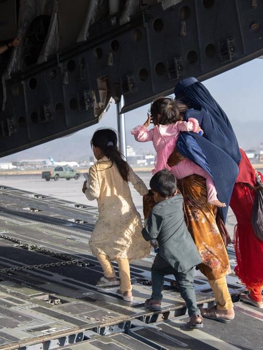 Eine afghanische Familie, Mutter mit ihren Kindern, ist auf dem Weg in ein Frachtflugzeug des US-Militärs, um vom Flughafen in Kabul ausgeflogen zu werden. 20210824_szp_z03_065 Copyright: xSgt.xDonaldxR.xAllen/USAFx