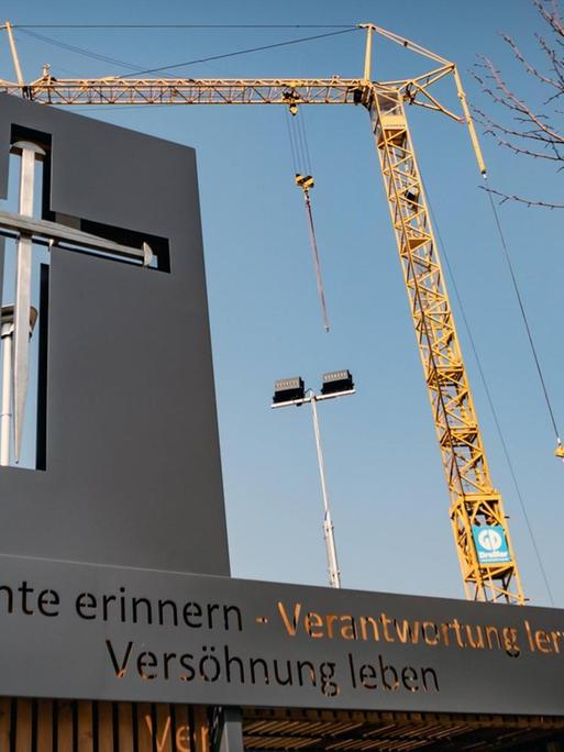 Vor einem Baukran an der Baustelle für den Wiederaufbau der Garnisonkirche in Potsdam ist ein stilisiertes christliches Kreuz zu sehen. Die Botschaft darunter lautet: Geschichte erinnern - Verantwortung lernen - Versöhnung leben