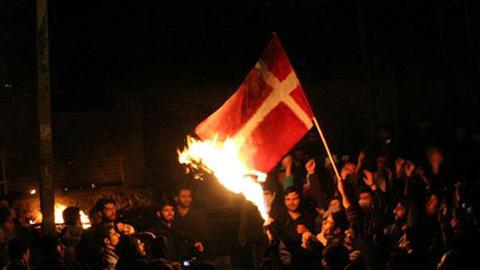 Islamische Demonstranten verbrennen vor der dänische Botschaft in Teheran eine Flagge.