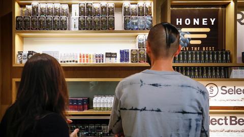 Junge Erwachsene stehen vor einer Auslage mit Vaping-Produkten in den USA.