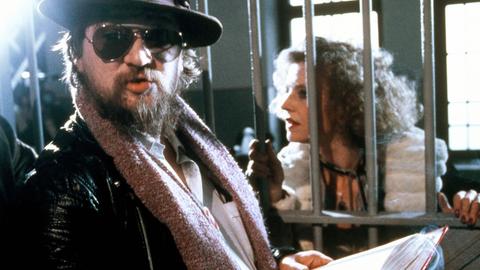 Das Bild zeigt den Regisseur Rainer Werner Fassbinder bei Filmaufnahmen.