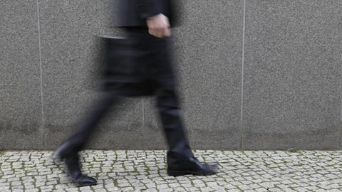 Geschäftsmann mit Aktenkoffer läuft auf der Straße