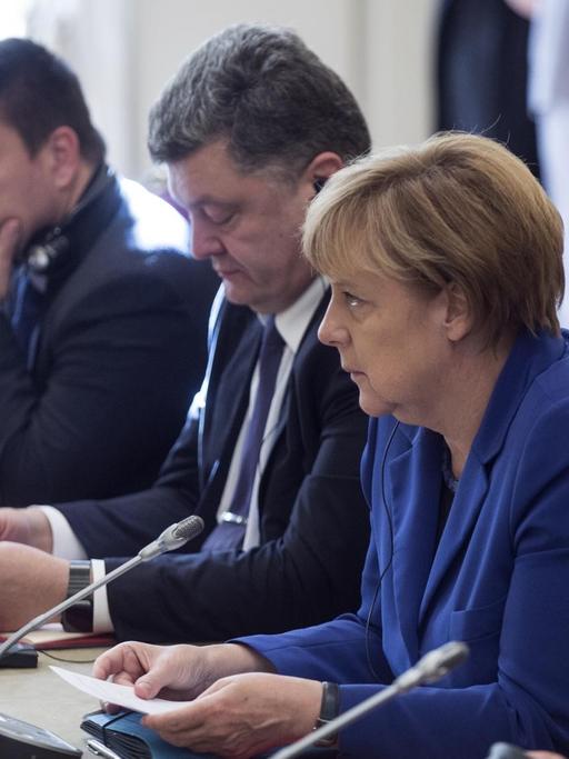 Bundesaußenminister Frank-Walter Steinmeier, Bundeskanzlerin Angela Merkel und der ukrainische Präsident Petro Poroschenko beraten beim Ukraine-Gipfel in Paris.