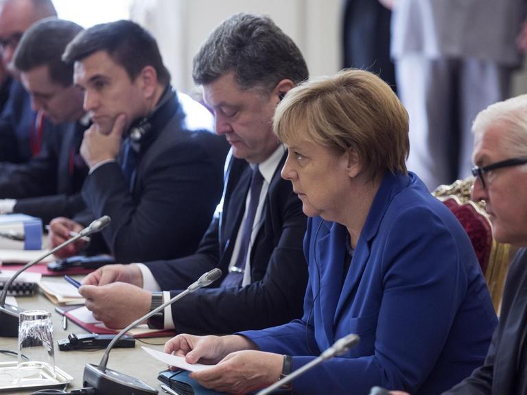 Bundesaußenminister Frank-Walter Steinmeier, Bundeskanzlerin Angela Merkel und der ukrainische Präsident Petro Poroschenko beraten beim Ukraine-Gipfel in Paris.