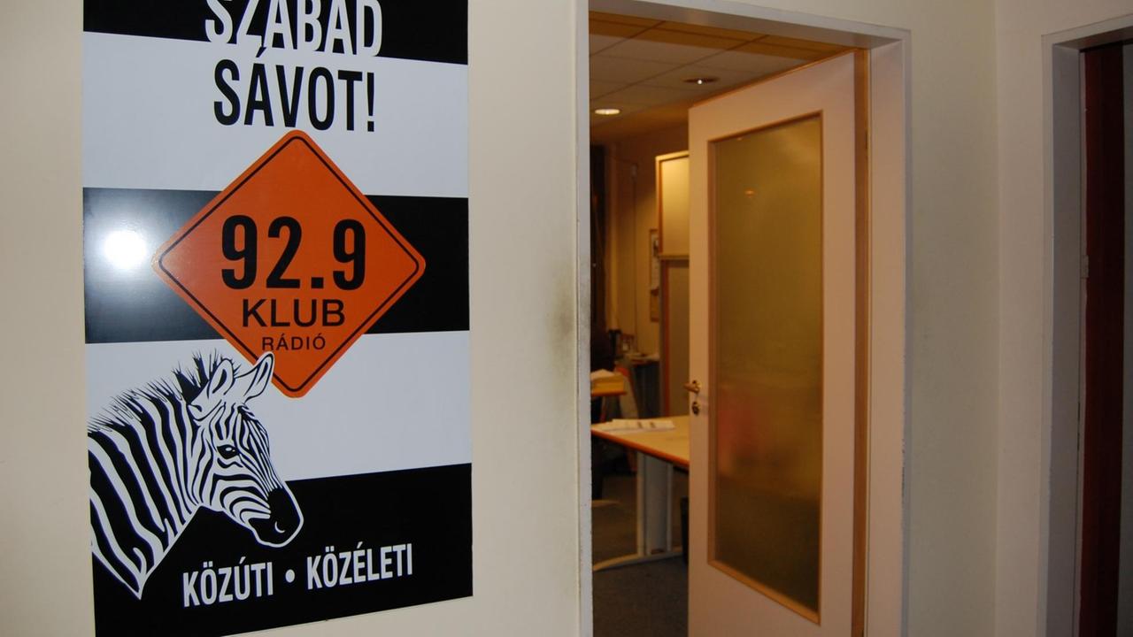 Werbetafel vom Klubradio, daneben offene Tür, die in die Redaktionsräume führt