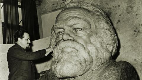 Der Bildhauer Laurence Bradshaw bei der Arbeit an einer Büste für das Grabmal von Karl Marx auf dem Friedhof Highgate in London, 1955. Karl Marx (1818–1883) war Philosoph und Nationalökonom und der Begründer des Marxismus.