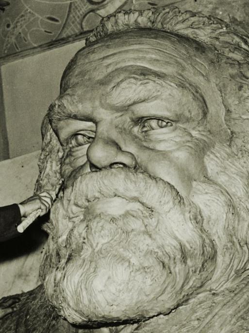 Der Bildhauer Laurence Bradshaw bei der Arbeit an einer Büste für das Grabmal von Karl Marx auf dem Friedhof Highgate in London, 1955. Karl Marx (1818–1883) war Philosoph und Nationalökonom und der Begründer des Marxismus.