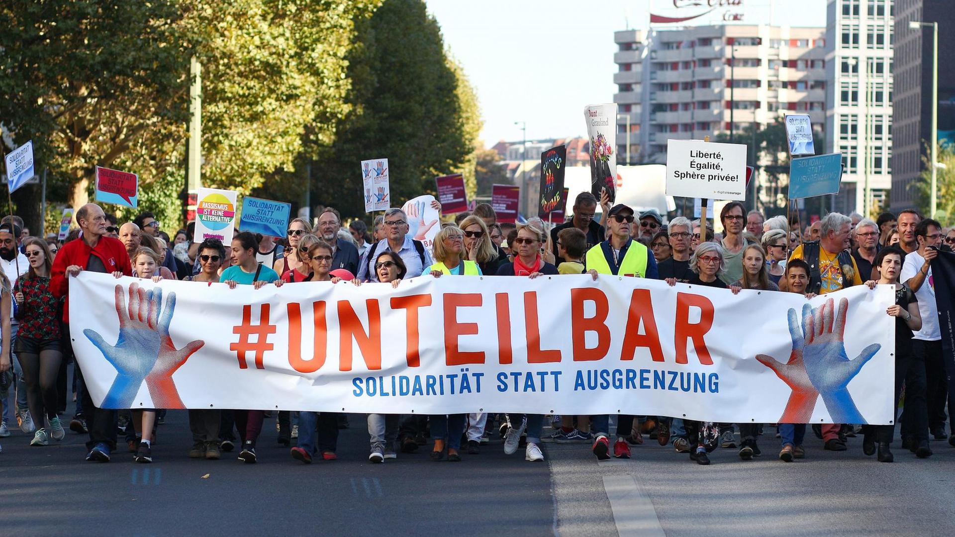 Teilnehmer der Demonstration unter dem Motto "Unteilbar Solidarität statt Ausgrenzung" tragen an der Spitze der Demo ein Transparent.