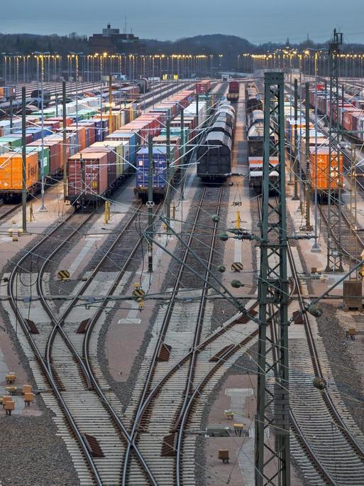 Abgestellte Güterwaggons auf Gleisen bei Dämmerung auf dem Rangierbahnhof Maschen in Niedersachsen