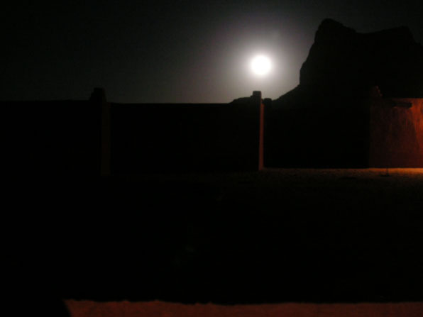 Tamanrasset by night: Vollmond hinter Berggipfel Tamanrasset by night: Vollmond hinter Berggipfel