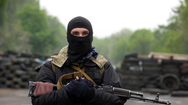 Ein prorussischer Aktivist steht mit einer Waffe an einem Checkpoint nahe der Stadt Slawiansk.