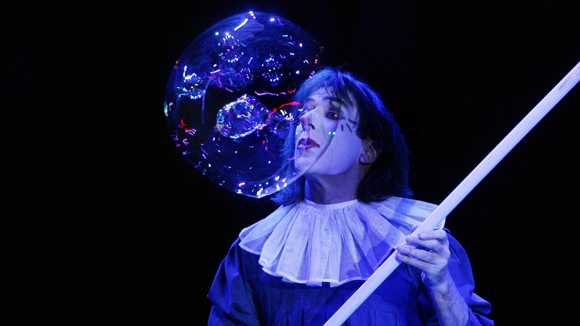 Clown Pic bei der Premiere vom Zirkus Roncalli's Weihnachtszirkus im Tempodrom in Berlin. Er bläst in eine riesige Seifenblase, die vor ihm schwebt, und trägt sein Pierrot-Kostüm.