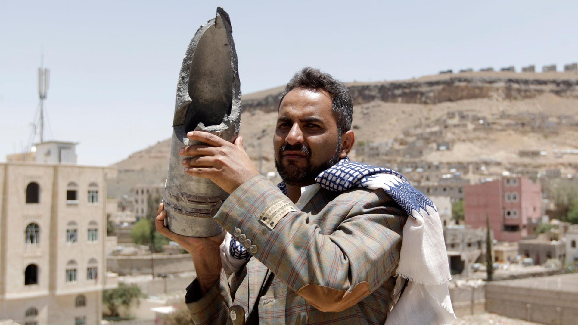 Ein Bewohner der jemenitischen Hauptstadt Sanaa hält die Überreste einer Bombe hoch, die von einem Luftangriff der von Saudi-Arabien angeführten Militärallianz stammt.