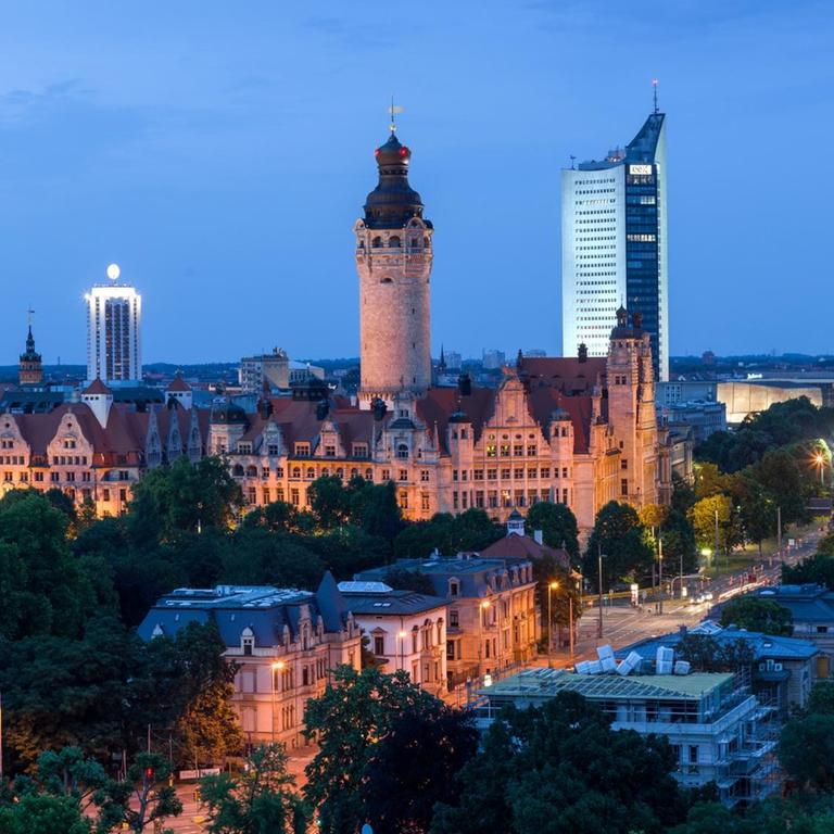 Das Foto zeigt den abendlichen Blick auf das Zentrum von Leipzig mit der Nikolaikirche, dem Wintergartenhochhaus, dem neuen Rathaus, Cityhochhaus und der neuen katholischen Probsteikirche.