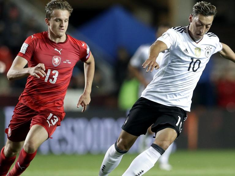 Das Bild zeigt einen Zweikampf zwischen dem deutschen Fußball-Nationalspieler Mesut Özil und dem Tschechen Jan Kopic.
