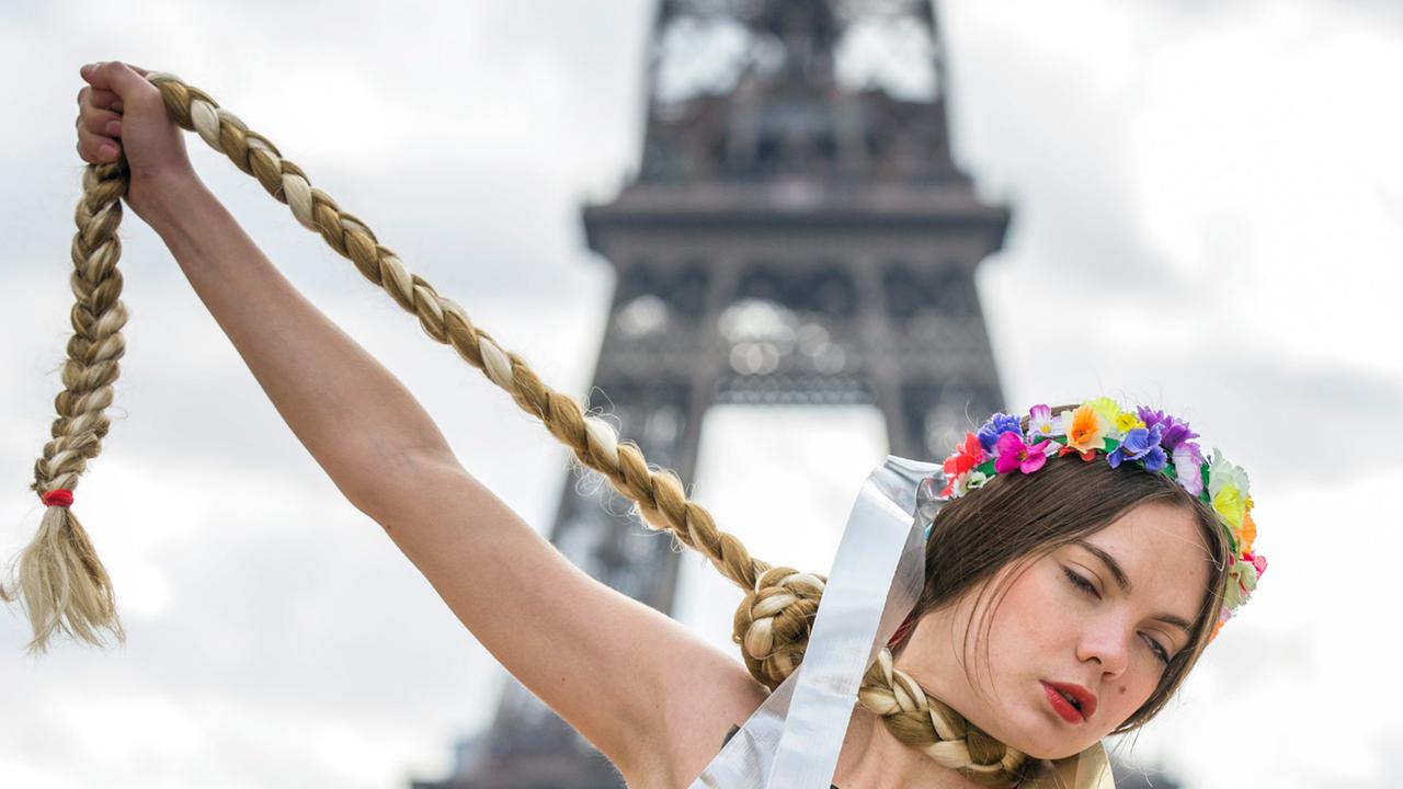 Eine Frau protestiert vor dem Pariser Eifelturm