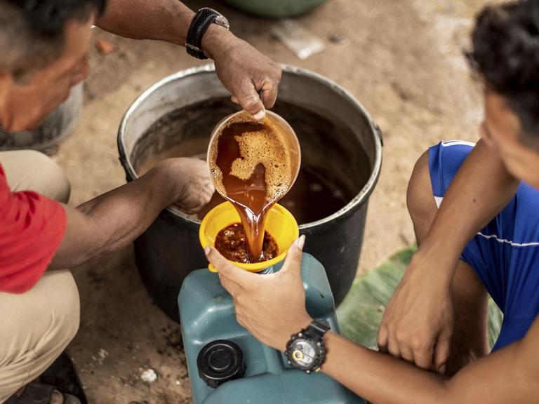 17.07.2018, Peru, Pucallpa: Ein Schamane (r) gibt einen Sud aus «Ayahuasca» in einen Becher. Das Gebräu, das aus der Liane Banisteriopsis caapi vorbereitet wird, wird in der peruanischen Shipibo-Ethnie sowie in diversen Amazonas-Ethnien zu medizinischen oder religiösen Zwecken eingesetzt