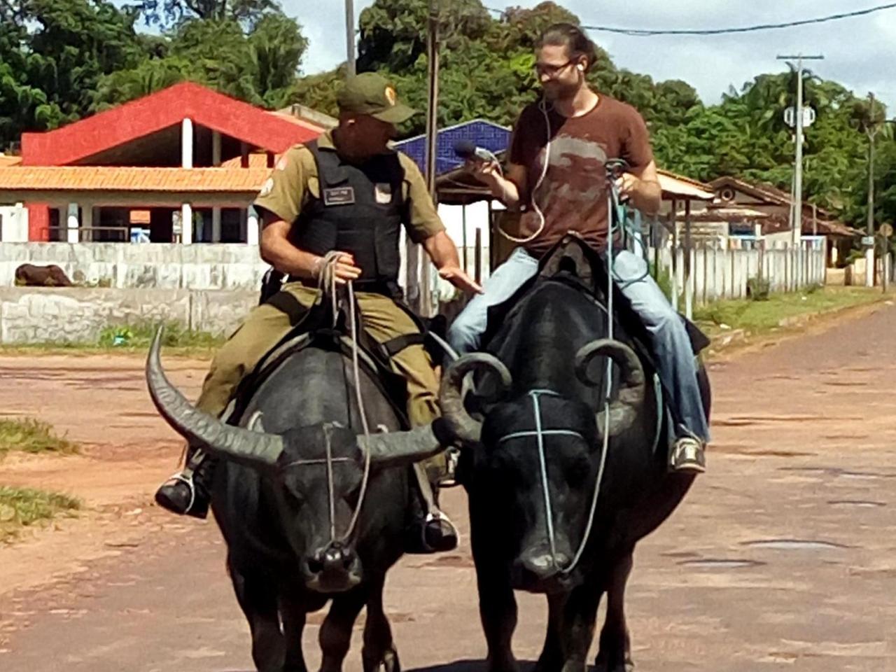 Militärpolizist Claudio Vitelli reitet auf einem Büffel. Rechts ist Autor Carsten Upadek. Er reitet ebenfalls einen Büffel