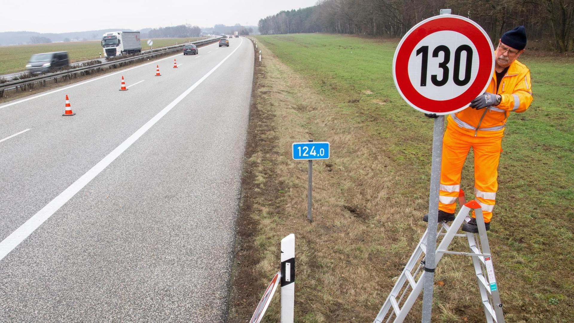 An der A 24 bei Suckow (Mecklenburg-Vorpommern) wird ein Straßenschild mit der Geschwindigkeitsangabe 130 km/h montiert.
