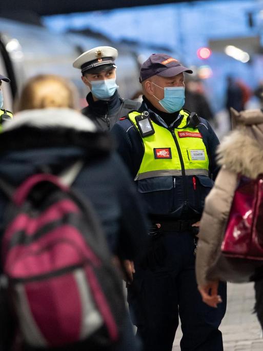 Sicherheitsmitarbeiter der Deutsche Bahn kontrollieren zusammen mit Polizisten der Bundespolizei die Einhaltung der Maskenpflicht am Hauptbahnhof in München.