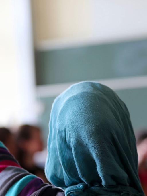 Eine Schülerin mit Kopftuch aus der Türkei meldet sich im Unterricht am 10.06.2013 in Oberhausen (Nordrhein-Westfalen)