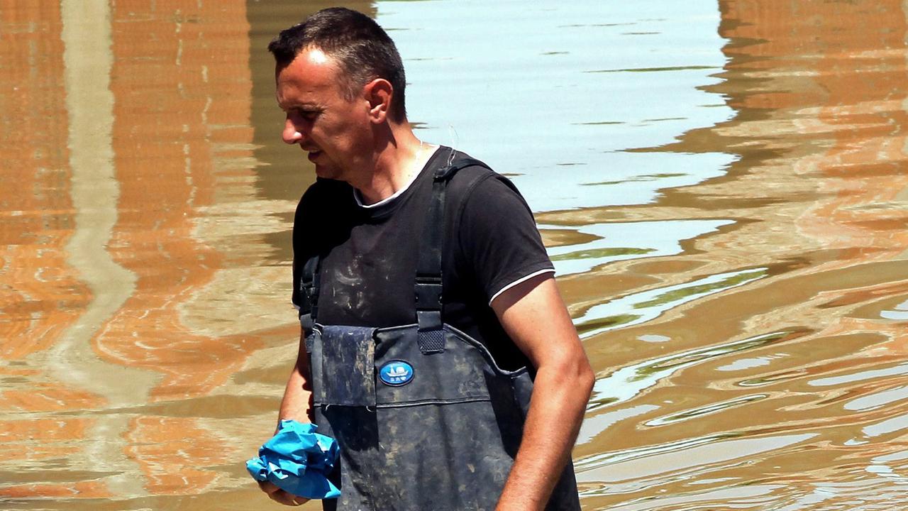 Ein Mann watet in Bosnien durch das Hochwasser. Ein Mann watet in Bosnien durch das Hochwasser.