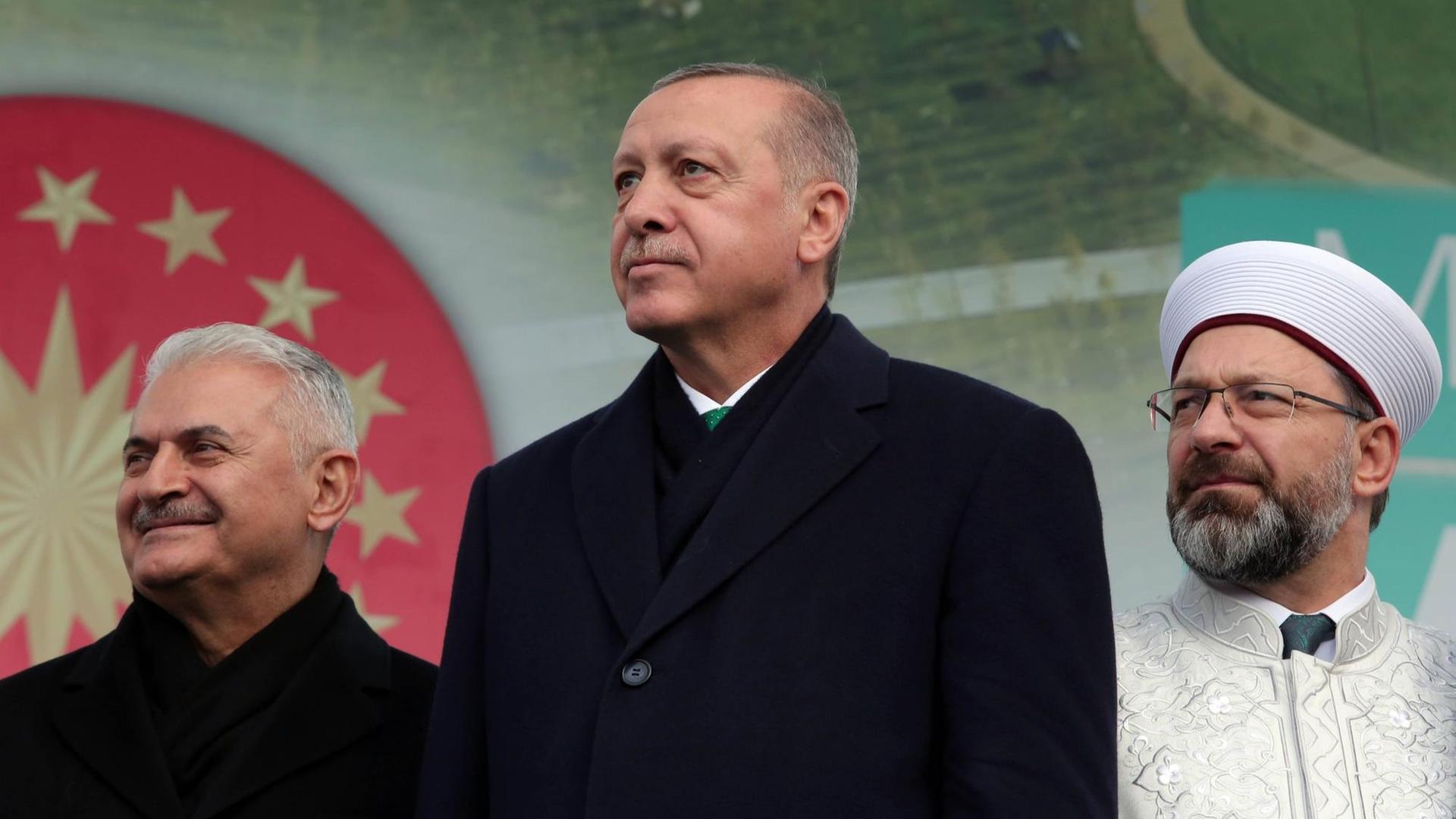 Präsident Erdogan bei einer Eröffnungsrede für einen öffentlichen Garten in Istanbul. Hinter ihm stehen Parlamentssprecher Binali Yildirim (l.) und das Oberhaupt der türkischen Religionsbehörde Diyanet, Ali Erbas (r.) (Foto vom 17.11.2018)
